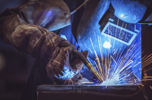 Industrial Worker at the factory welding steel structure